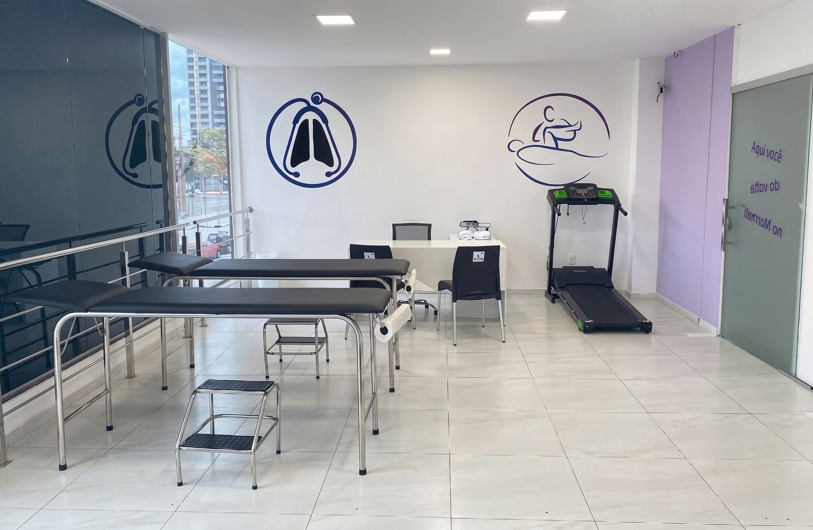 Sala com macas, esteira ergométrica e mesa de atendimento
